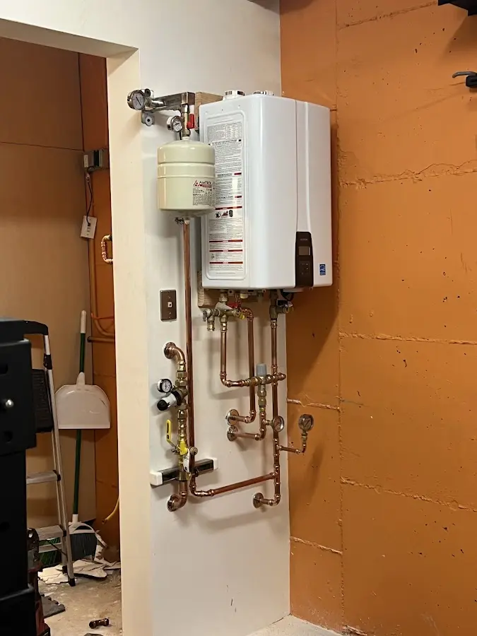 Plumbing technician inspecting water heater connections in South Abington